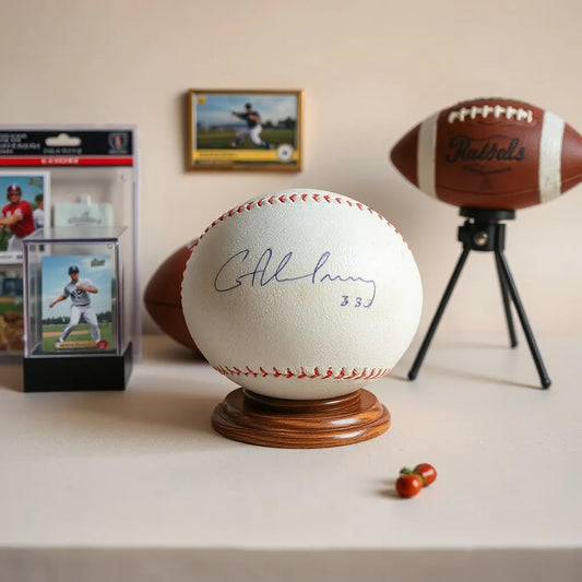 Curated display of sports memorabilia collectibles, including autographed ball and trading cards in protective cases