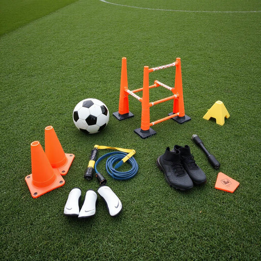 Agility cones, speed ladder, training ball, and resistance band laid out on a soccer field for practice