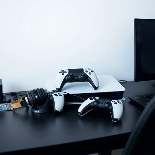 PS5 gaming setup with controller dock, headset, and ergonomic controller accessories on a desk