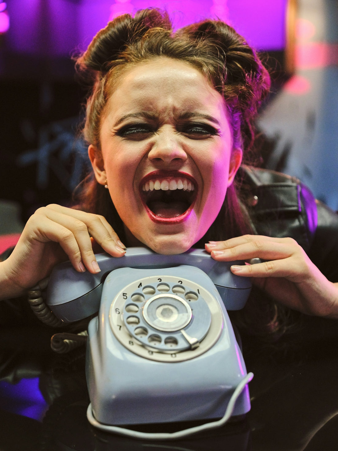 girl holding gray rotary-dial telephone
