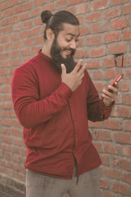 a man with a beard pointing at a cell phone