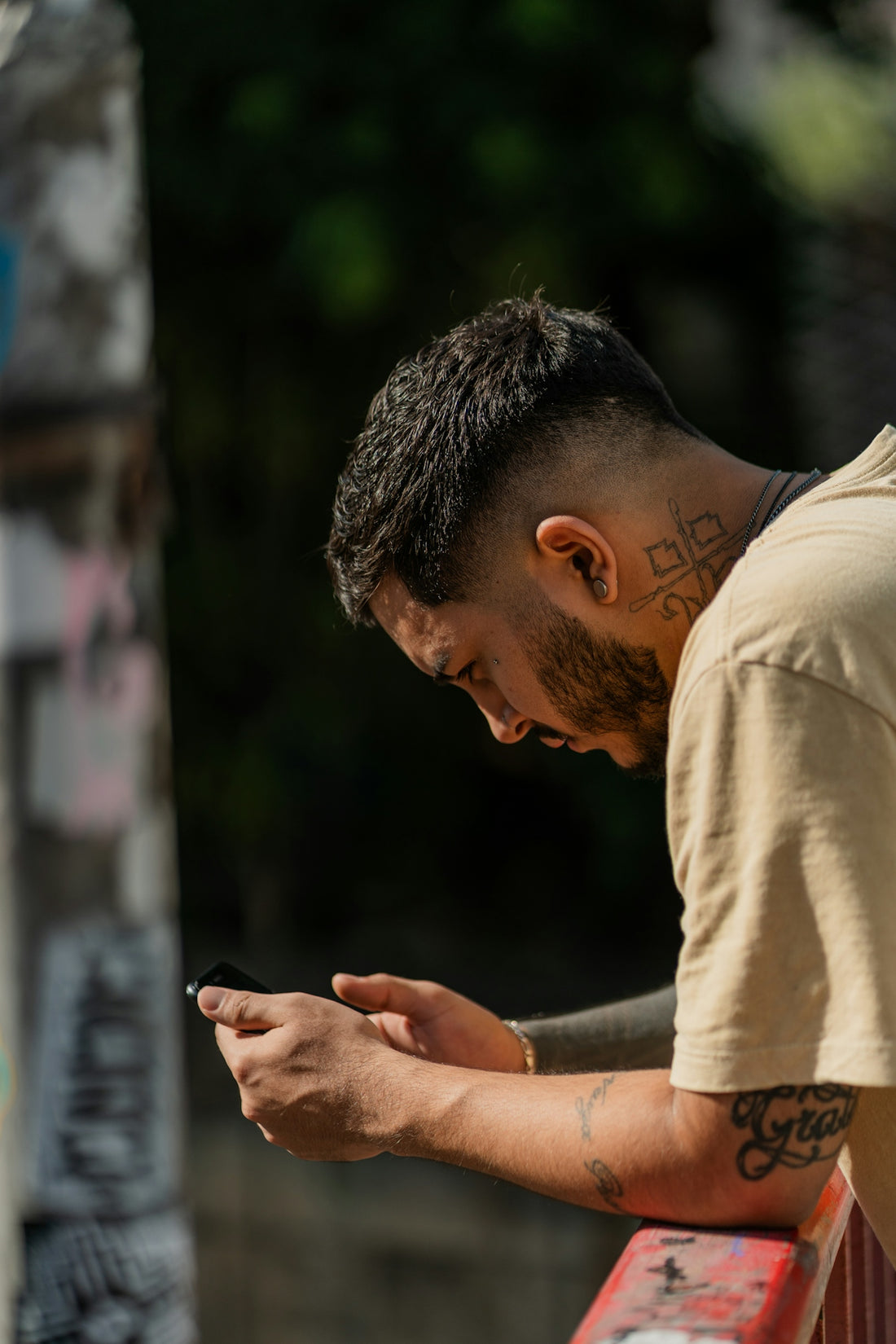 a man sitting on a bench looking at his phone