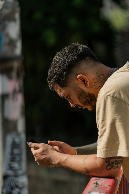 a man sitting on a bench looking at his phone