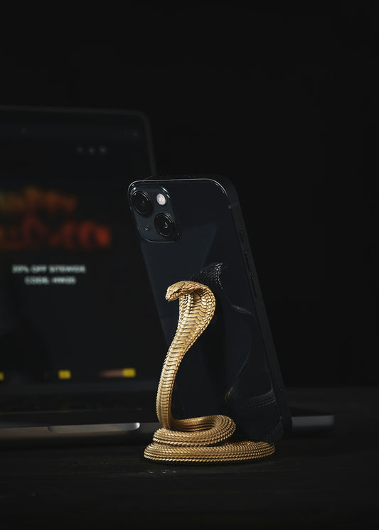 a phone with a gold snake on it next to a laptop