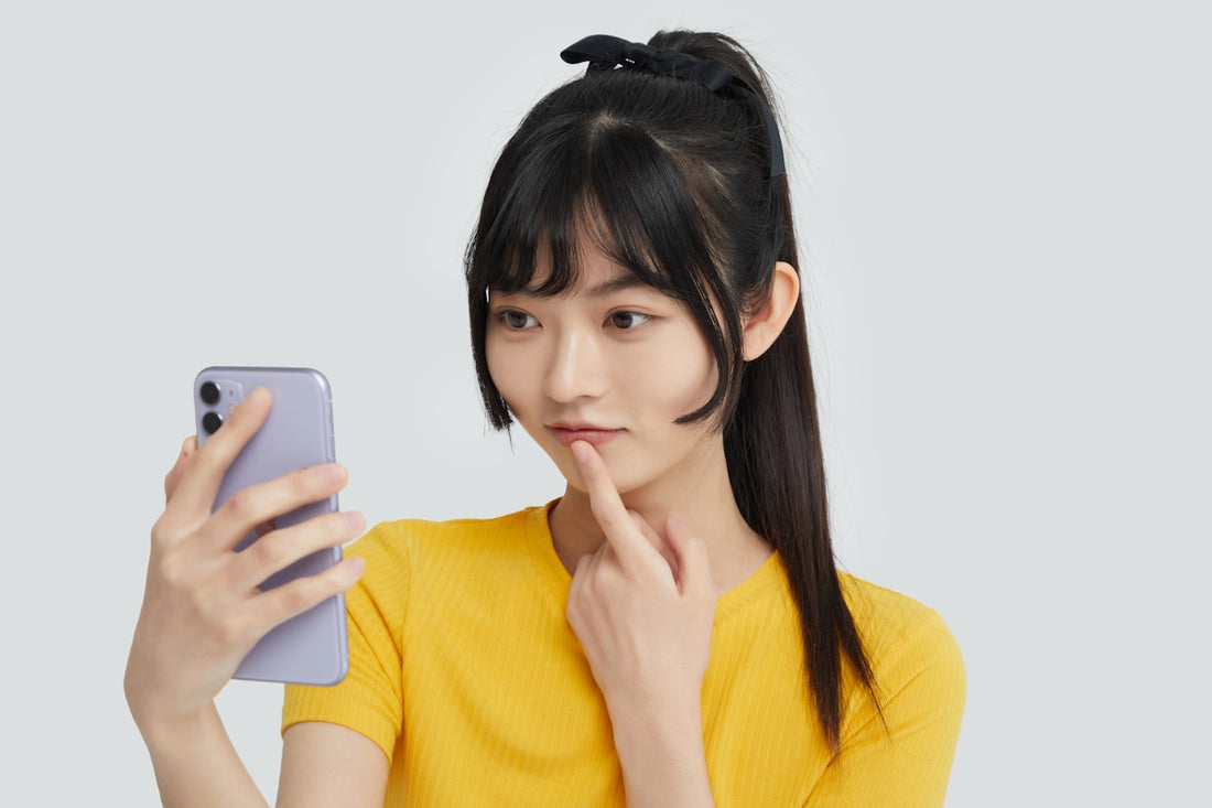 a woman in a yellow shirt holding a cell phone