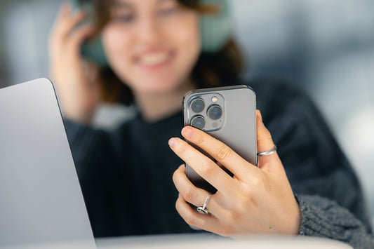 A woman looking at her cell phone while sitting at a table
