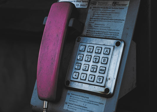 An old style phone is attached to a wall