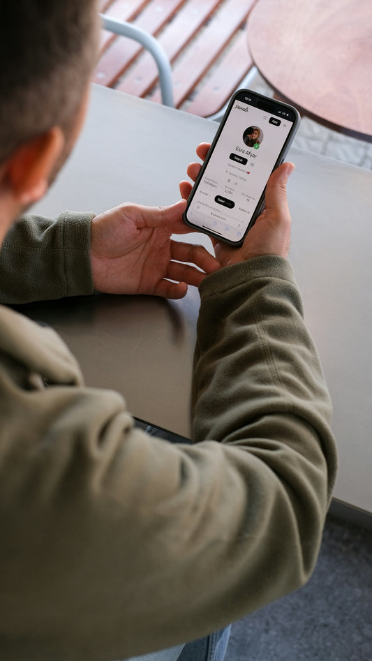 A man sitting at a table using a cell phone