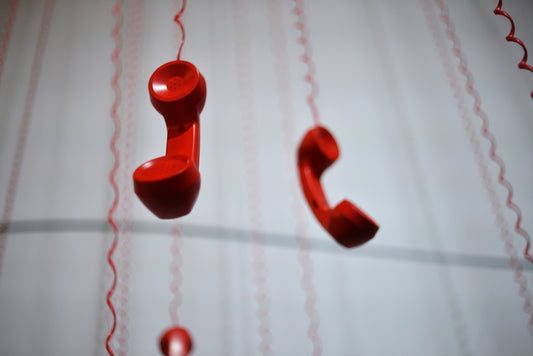 Red phone handsets hang from above.