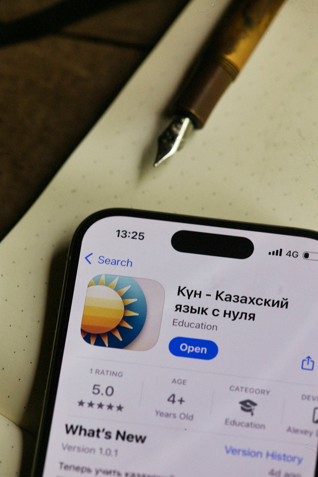 A phone displays a kazakh language learning app.
