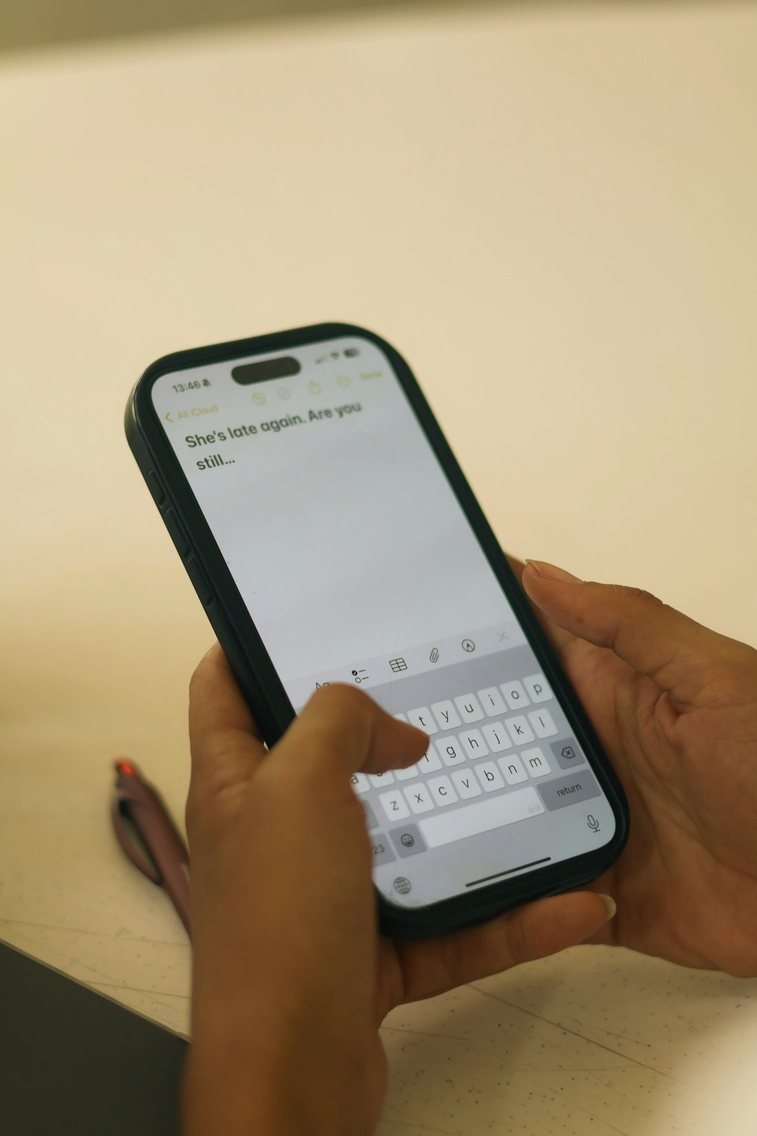 Hands typing on a smartphone with a message on screen.