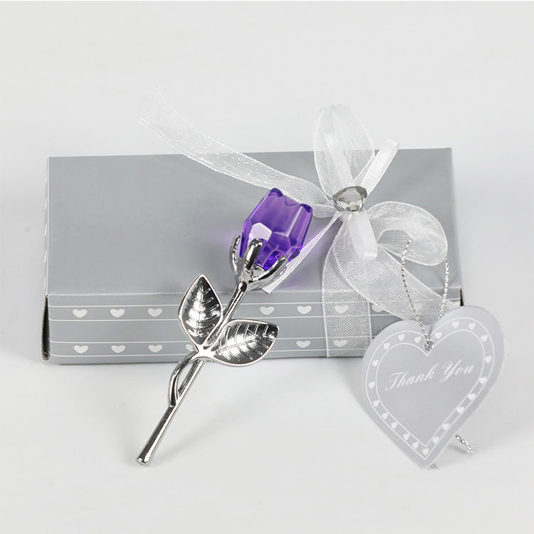 An elegant purple crystal glass rose ornament with silver leaves and stem, tied with a white bow next to a heart-shaped 'thank you' tag, presented before a grey gift box adorned with white hearts from SammySKFootball's Valentines Day Gift Crystal Glass Rose Artificial Flower Silver Gold Rod Rose.